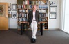 university of california irvine professor and cannabis researcher daniele piomelli standing in front of his desk and a bookcase with legs crossed in khaki packs and brown sportscoat