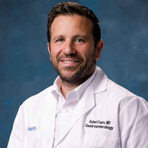 uci health gastroenterologist dr robert fearn wearing a white coat in front of a blue studio background
